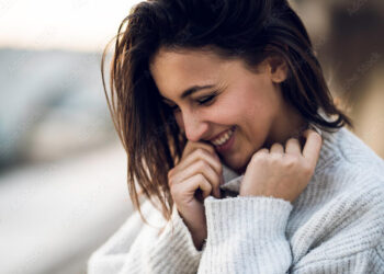 ragazza-che-ride-timidamente-mani-viso