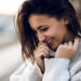 ragazza-che-ride-timidamente-mani-viso